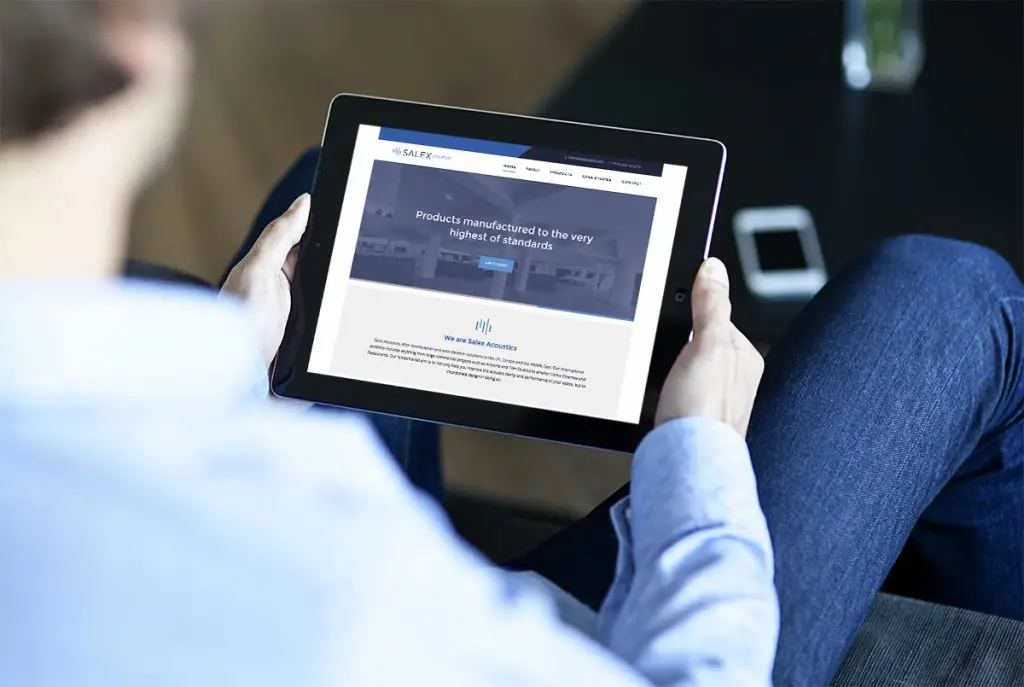An image of a man holding an iPad with the Salex website on display