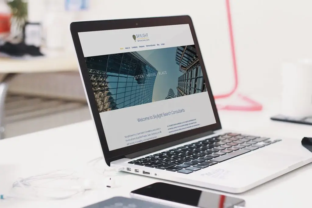 An image of the Skylight Search website displayed on an Apple Mac laptop